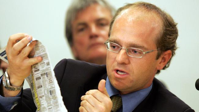 Neil Gilmore in 2005 during a public hearing into legalisation of escort services in Queensland. Here he points out which of the Gold Coast Bulletin escort advertisements are illegal workers. Picture: supplied.