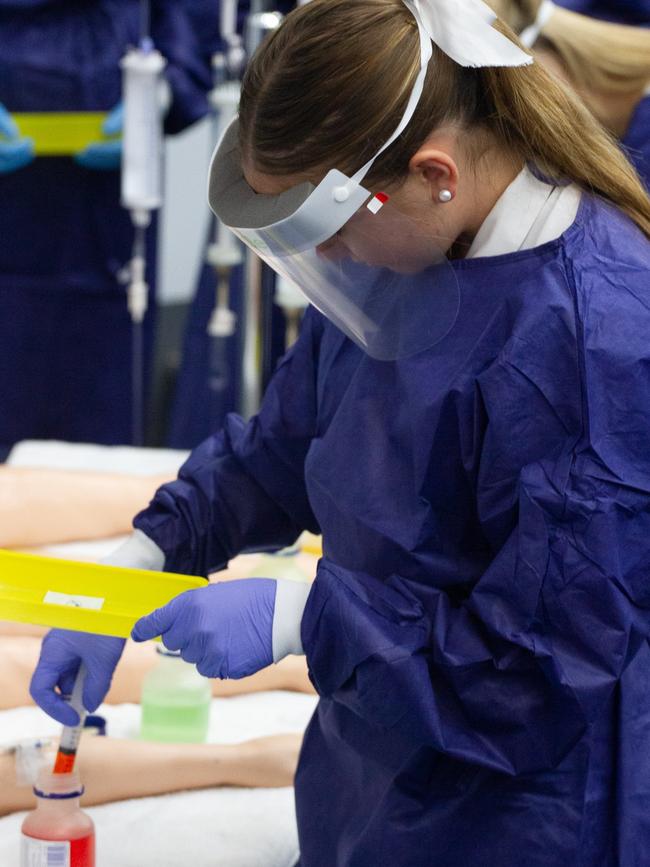 A future nursing student carefully withdraws liquids into her syringe.