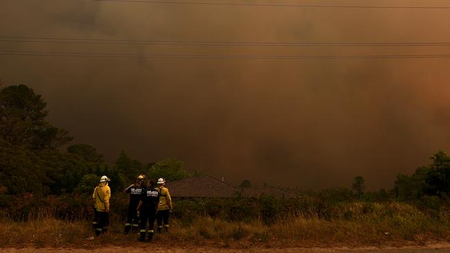 NSW Rural Fire Service and Fire and Rescue NSW firefighters watch on as the Grose Valley Fire approaches Kurrajong Heights on December 21, 2019. (AAP Image/Dan Himbrechts)