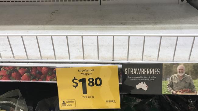 Empty shelves, normally stocked with strawberry punnets, at a Coles Supermarket in Brisbane. Picture: AAP/Darren England