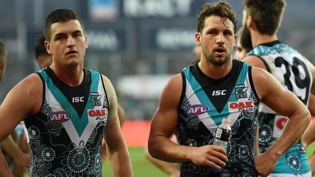 Tom Rockliff and Travis Boak leave the ground after going down to Hawthorn. Picture: AAP Images