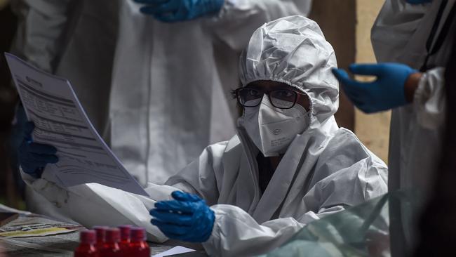 A health worker checks documents while conducting COVID-19 tests on people in Mumbai. Picture: AFP