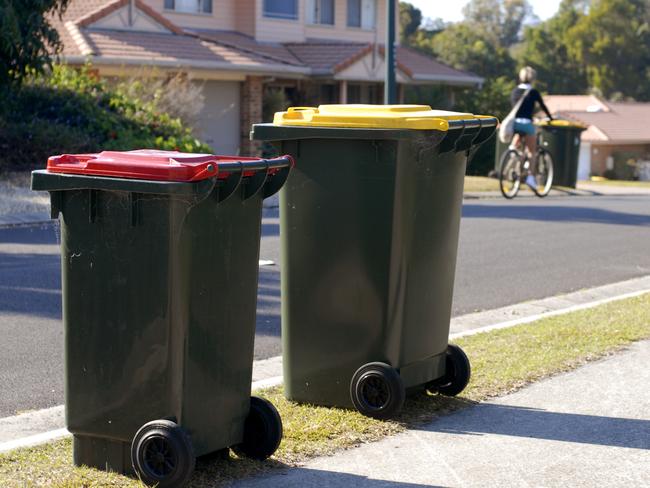 Two rubbish bins in Australia. Red lid is rubbish, yellow lid is recycling.