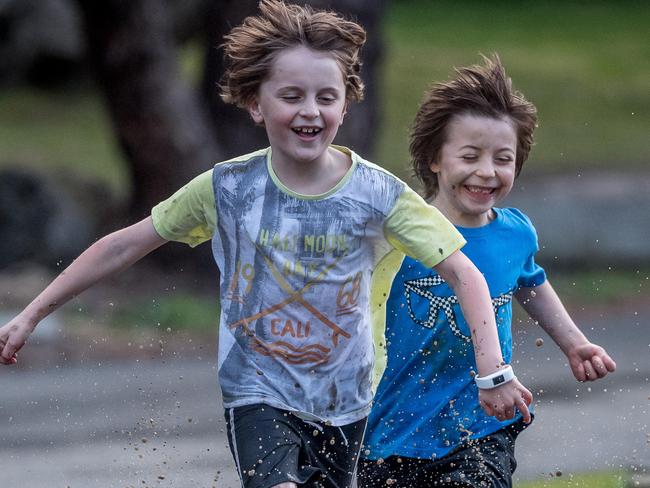 Louis and Felix race through a muddy puddle. Picture: Jake Nowakowski