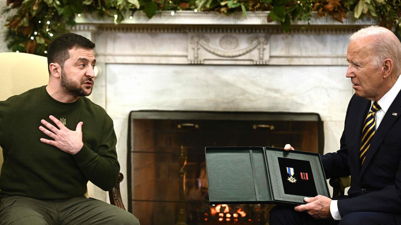 Ukraine's President Volodymyr Zelenskyy presents a visibly moved US President Joe Biden with his country’s Merit Award. Picture: AFP