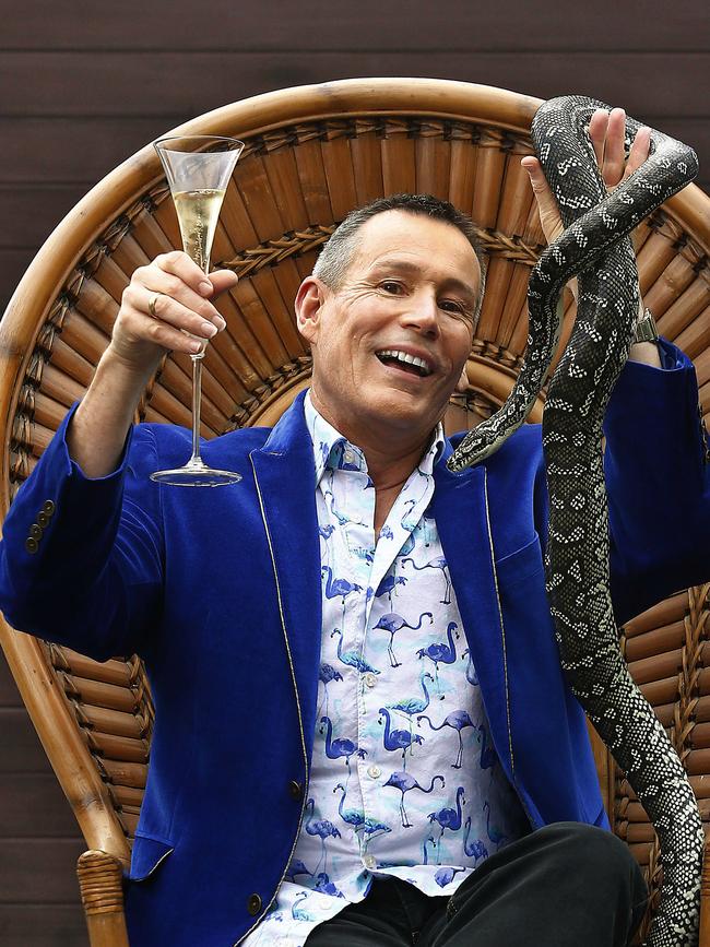 Craig Bennett with a glass of bubbles and his intergrade python. Picture: John Appleyard