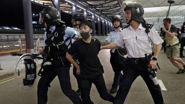 Policemen arrest a protester during a clash at Hong Kong international airport. Picture: AP.