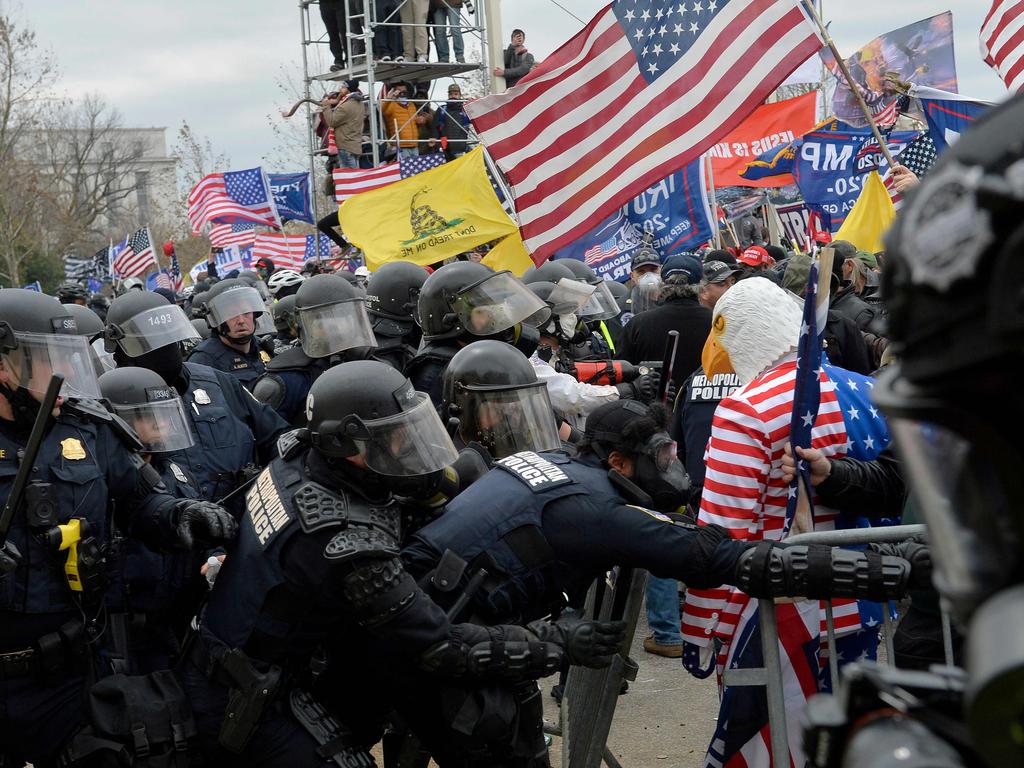 Trump supporters clash with police and security forces as they try to storm the US Capitol surrounded by tear gas in Washington, DC. Picture: AFP