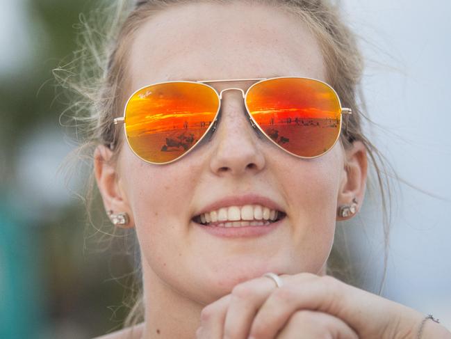 Hot Weather at St Kilda Beach. People flock to the beach on scorching 42 degree day. The sun set reflects in Ashleigh Brand-Oliver's sunglasses. Picture: Eugene Hyland