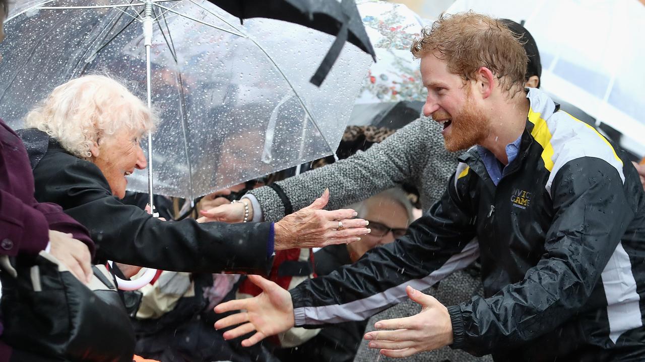 Prince Harry hugs 97 year old Daphne Dunne during a walkabout in the torrential rain in Sydney on June 7, 2017. Picture: Chris Jackson/Getty Images