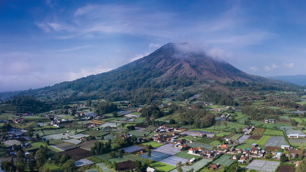 Batur volcano sitting in a volcanic caldeira with local farms in North Bali in Indonesia.