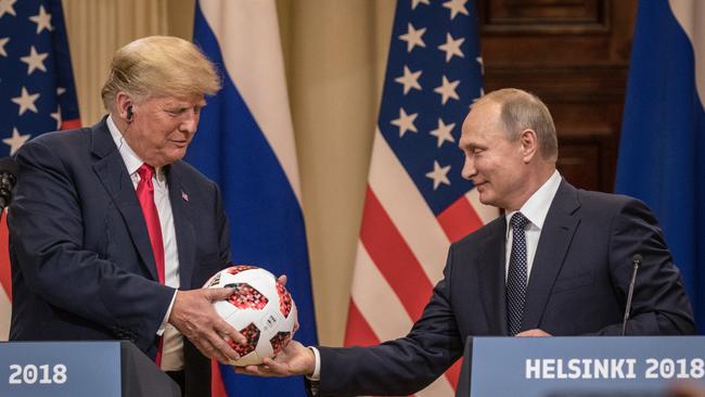 Going soft: Vladimir Putin hands Donald Trump a World Cup football after their summit in Helsinki yesterday. Picture: Getty Images