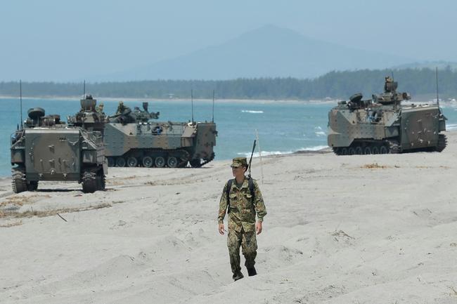 A Japanese Ground Home Defence Forces' soldier walks past amphibious assault vehicles during an  landing exercise in San Antonio town, in the Philippines in 2018