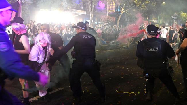 A woman was seen being grabbed by officers, with signs from the Rainbow Labor contingent, where Mr Minns was marching, seen in the background. Picture: NCA NewsWire / Jeremy Piper