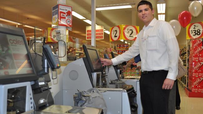 A Coles staff member at a self serve checkout in one of their Queensland stores. Picture: News Corp