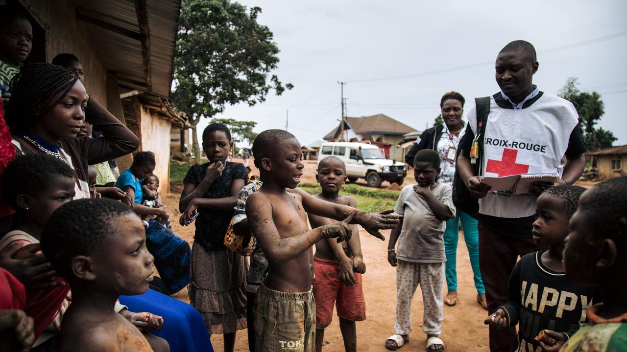 Members of the International Federation of the Red Cross and the Congolese Red Cross go door-to-door in the Beni neighbourhoods, northeastern Democratic Republic of Congo, to listen to families about their fear of the Ebola virus in 2019. Picture: Alexis Huguet/AFP