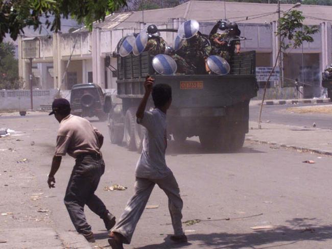 Get out ... children throw rocks at departing Indonesian troops in Dili, East Timor, 1999.