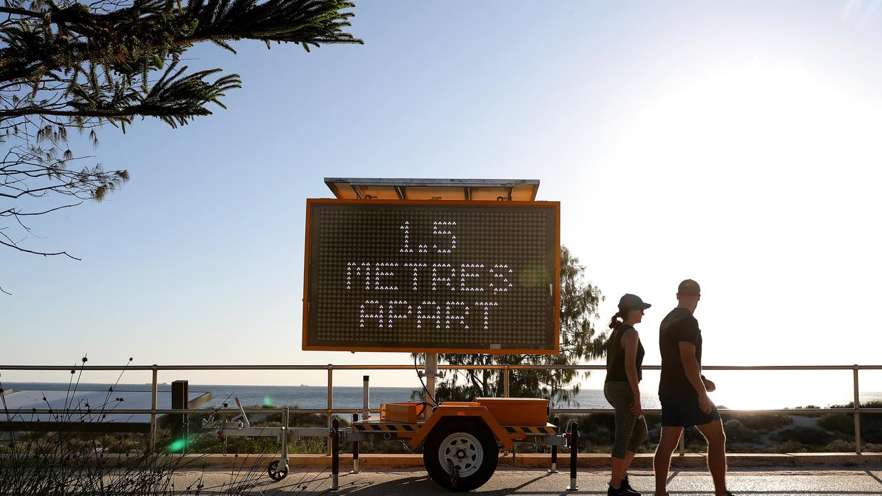 A sign at Scarborough Beach urges people to practice social distancing. Picture: Richard Wainwright/AAP