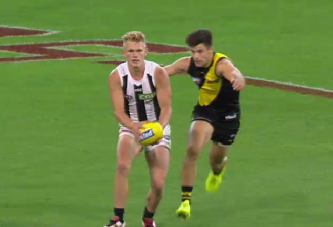 Richmond captain Trent Cotchin runs down Adam Treloar.