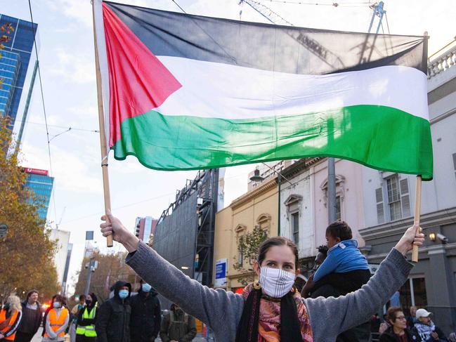 A woman waves a Palestinian flag as protesters march from the State Library to Parliament House. Picture: NCA NewsWire/Sarah Matray