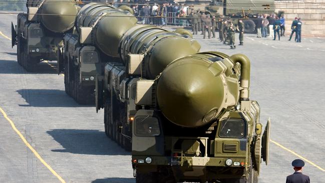 A Russian policeman stands in front of convoy of nuclear missiles in a military parade rehearsal in Red Square, Moscow.