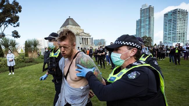 An anti-lockdown protester is arrested at the Shrine of Remembrance in Melbourne in Saturday.