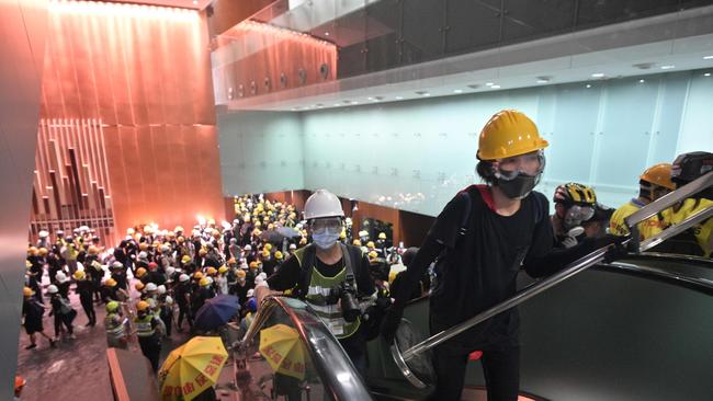 Protesters break into the government headquarters in Hong Kong on July 1, 2019, on the 22nd anniversary of the city's handover from Britain to China. - Anti-government protesters stormed Hong Kong's parliament building late on July 1 after successfully smashing their way through reinforced glass windows and prizing open metal shutters that were blocking their way. (Photo by Anthony WALLACE / AFP)