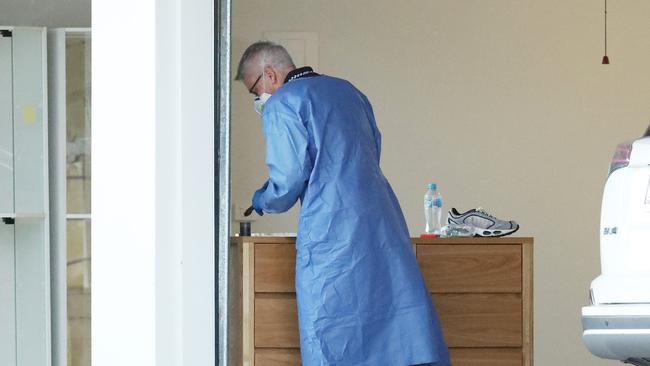 A forensic investigator examines the scene following a woman’s death. Picture: Liam Kidston.