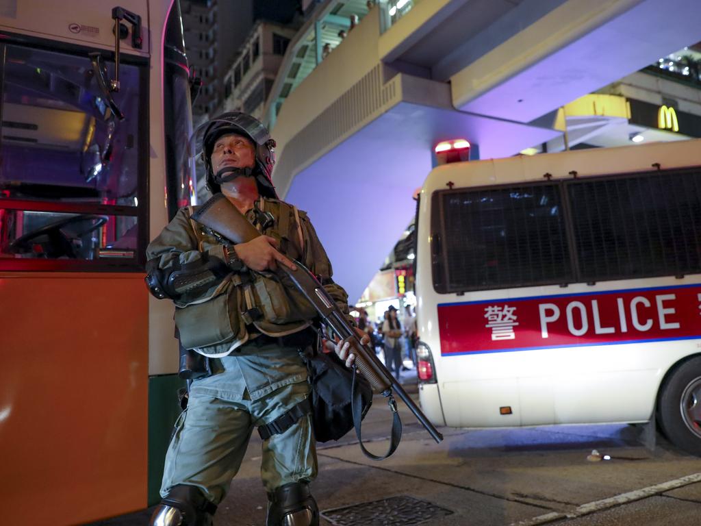 A police officer armed with a shotgun looks up at protesters during this weekend’s march. Picture: Vincent Thian/AP