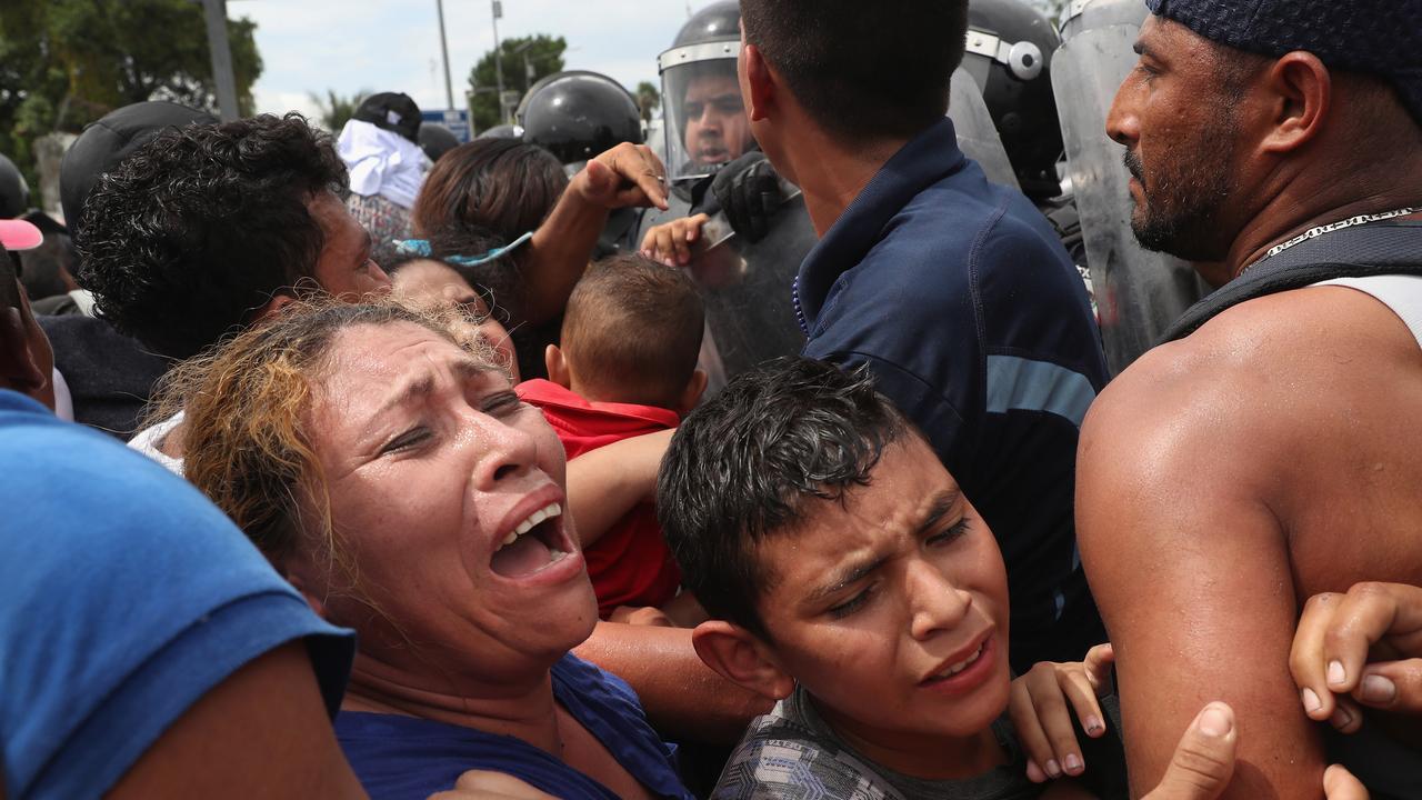 Members of the migrant caravan are pushed forward into Mexican riot police on the border between Mexico and Guatemala on October 19, 2018. Picture: Getty