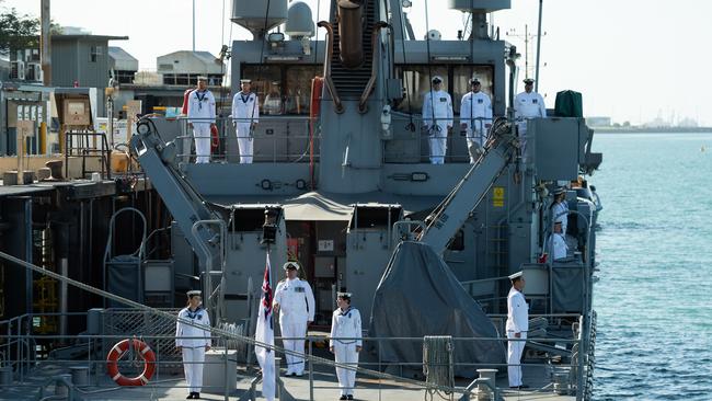 Crew members standing to attention aboard HMAS Broome (II) for the last time.