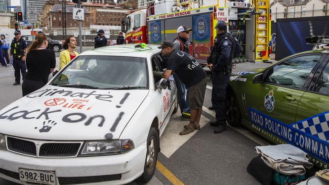 Extinction Rebellion activist Eric Herbert (centre) in a protest outside 1 Williams Street, Brisbane. Picture: AAP.