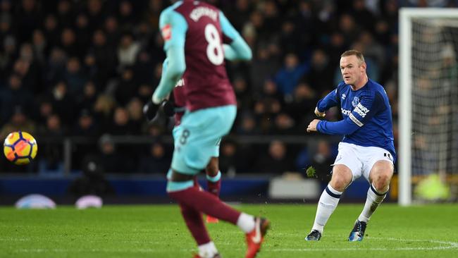 Everton's English striker Wayne Rooney (R) shoots from the half-way line.