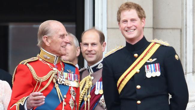 Prince Harry and Prince Philip, Duke of Edinburgh share a joke on the balcony during Trooping the Colour in 2014 in London.