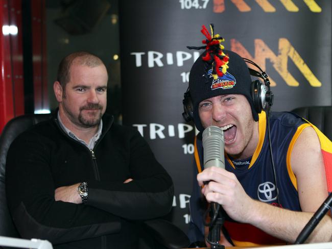 Mark Ricciuto in the Triple M studios with a Crows fan.