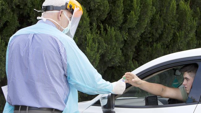 Doctor Rod Pearce helps a patient administer a Covid test in a car park earlier this year. Picture: Emma Brasier