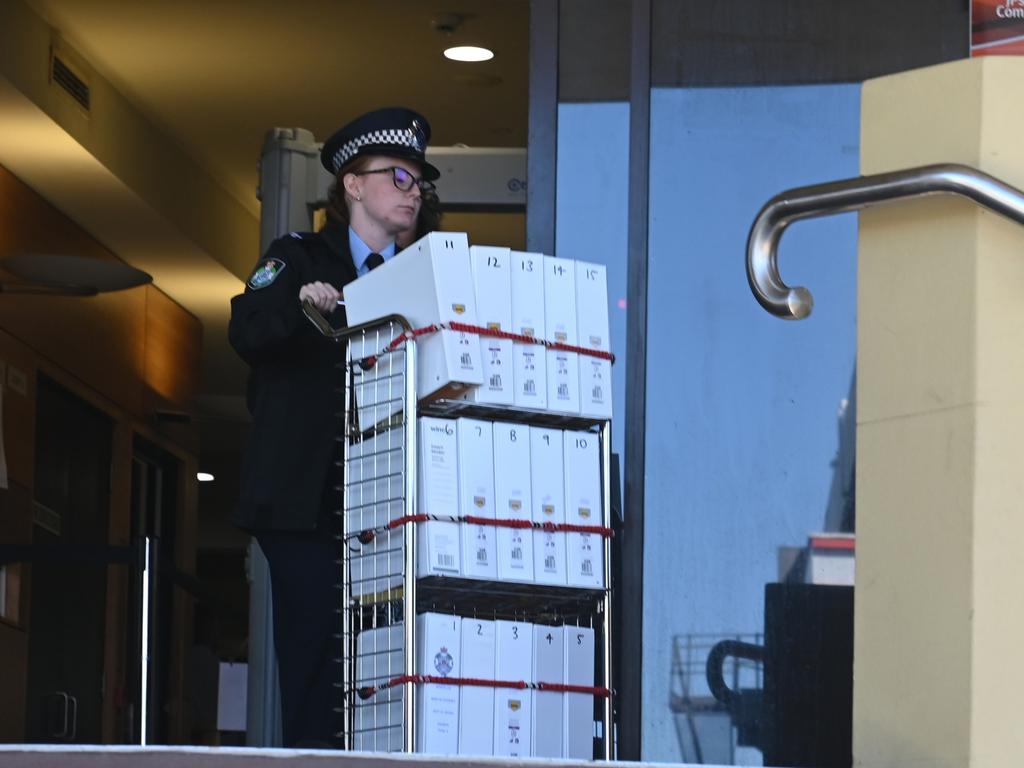 A police officer wheeling the massive brief of evidence in relation to the Bogie triple murder case from Mackay courthouse after the committal hearing for triple murder accused Darryl Valroy Young.