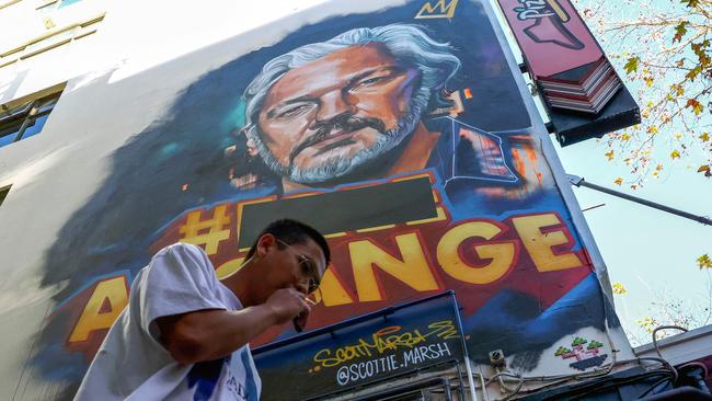 A man walks past a mural of WikiLeaks founder Julian Assange on George Street in Sydney’s CBD.