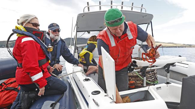 Ride along with the Tasmanian Police Marine and Rescue Services during Rock Lobster season patrols. Fisherman Shane Fava is approached by Police from the Marine and Rescue Services Senior Constable Michael Barber and Senior Constable Karina Lane as he heads back to Tinderbox boat ramp after recreational potting. Picture: Zak Simmonds