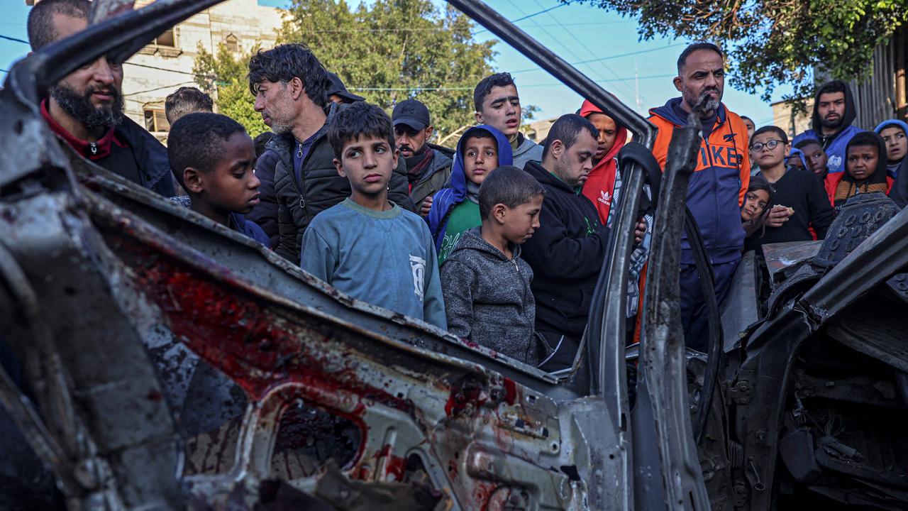 Onlookers gather around a car that was destroyed in an Israeli raid in Rafah in the southern Gaza Strip. Picture: AFP
