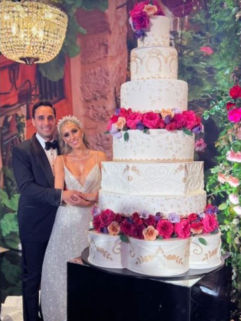 Lauren and her new husband cut into a 7-tier wedding cake.