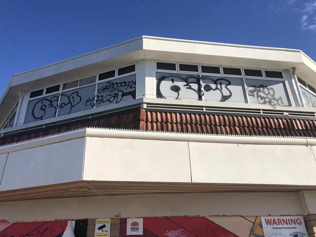 Graffiti vandalism on the top level of the former Sea Life Aquarium building in Manly Cove. Picture: Jim O’Rourke