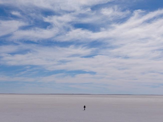 Charles Wooley is just a speck in the middle of the trackless white wilderness in the dry southern section of Lake Eyre. MUST CREDIT Arron Hage