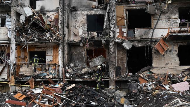 Firefighters work at a damaged residential building at Koshytsa Street, a suburb of the Ukrainian capital Kyiv, where a military shell allegedly hit. Picture: AFP