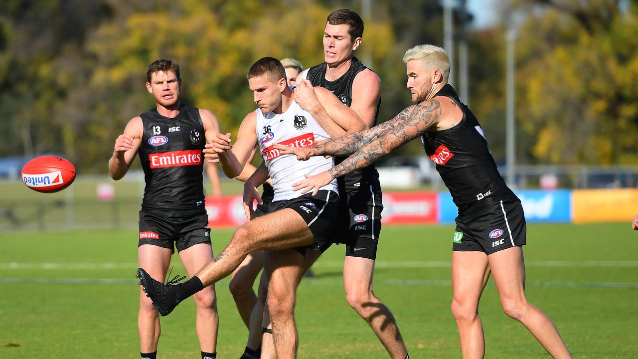 Brayden Sier of the Magpies kicks while being tackled by Mason Cox. Picture: Quinn Rooney