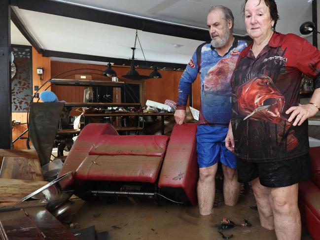 A monsoonal tropical low pressure system has brought devastating widespread flooding to North Queensland and parts of Far North Queensland, with over 1000 millimetres of rain recorded in some areas. Clitheroe Street residents David and Tracy Ebert lookfor items to salvage from the lounge room, after flood water inundated their Cardwell home overnight. Picture: Brendan Radke