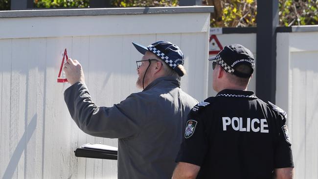 Police examine bullet holes in a fence following a police shooting. Picture: Peter Wallis