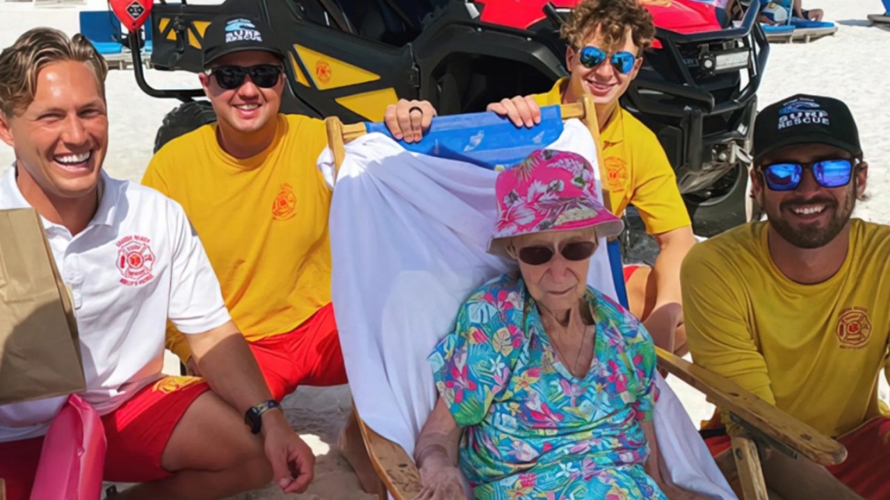 The lifeguards with the 95-year-old woman on beach. Picture: Orange Beach Surf Rescue