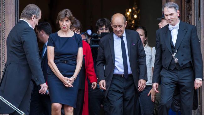 Newly appointed French Foreign Affairs Minister Catherine Colonna (C) escorts her predecessor Jean-Yves Le Drian (R) out of the Foreign Affairs Ministry at the end of a handover ceremony. Picture: AFP.