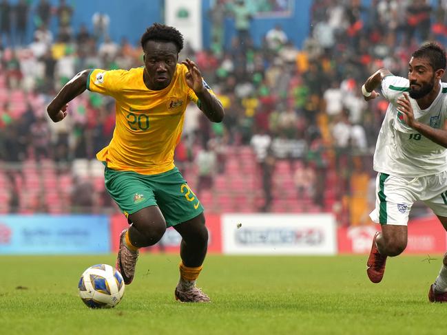 DHAKA, BANGLADESH - JUNE 06: Nestory Irankunda of Australia (L) controls the ball under pressure of Isa Faysal of Bangladesh (R) during the FIFA World Cup Asian second qualifier Group I match between Bangladesh and Australia at Bashundhara Kings Arena on June 6, 2024 in Dhaka, Bangladesh. (Photo by Thananuwat Srirasant/Getty Images)